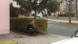 Beauty pissing on street behind bushes